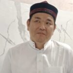 Ustadz Hasan Basri Fuk memakai baju putih dan peci hitam maroon saat memberikan tausiah tentang integritas dan amanah informasi